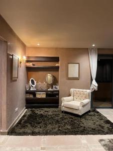 a living room with a white chair and a mirror at Villa Marrakech piscine privée vue sur Golf&Atlas in Marrakech