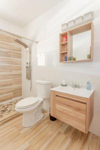 ein weißes Bad mit einem WC und einem Waschbecken in der Unterkunft Villas Palmar in Aguadilla