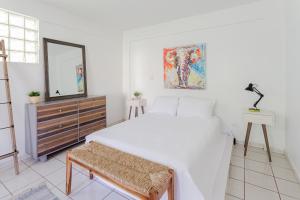 ein Schlafzimmer mit einem Bett, einem Spiegel und einer Kommode in der Unterkunft Villas Palmar in Aguadilla