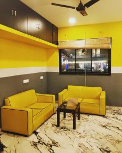 a living room with two yellow couches and a table at 29 Beach House Goa in Morjim