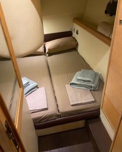 een klein bed in een kleine kamer met handdoeken bij Miamoryacht in Nydri