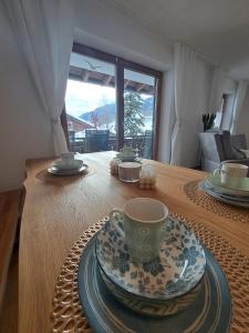 a wooden table with a cup and a plate on it at Alpenfee Ofterschwang mit E-Bike Garage in Ofterschwang