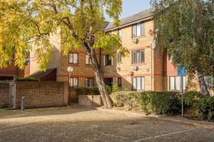 ein Backsteingebäude mit einem Baum davor in der Unterkunft 2 Double Beds Modern Refurb Flat - 10 min 2 London Bridge in London