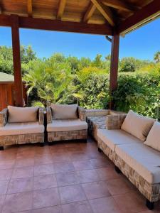 a porch with couches on a patio at Villetta tre delfini in Custonaci