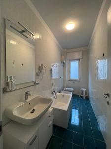 a bathroom with a sink and a tub and a mirror at La Veronica Apartment in Naples