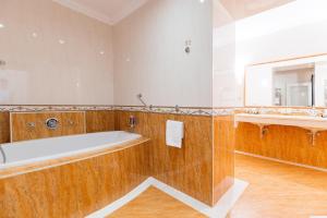 a bathroom with a tub and a large mirror at Grandhotel Zvon in České Budějovice