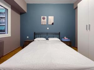um quarto com uma cama grande e uma parede azul em 4-bedroom Dream Apartment em Atenas