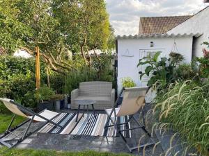 a patio with two chairs and a table and chairs at Appartement au gré des bulles in Cucq