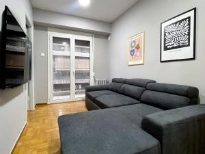 uma sala de estar com um sofá e uma televisão de ecrã plano em 4-bedroom Dream Apartment em Atenas