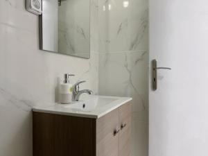 uma casa de banho com um lavatório e um espelho em 4-bedroom Dream Apartment em Atenas