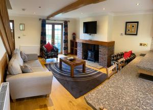a living room with a couch and a fireplace at Red House Farm Cottages in Beverley