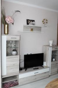 a living room with a tv on a wooden entertainment center at Dzintara apartamenti in Kuldīga +26 photos
