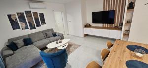 a living room with a couch and a table at Apartments Lisinski - Private parking in Zagreb