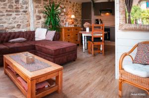 een woonkamer met een bank en een tafel bij RÉF 213 - RIANTEC Ty Maya Gîte sur propriété chaumière avec piscine partagée in Riantec