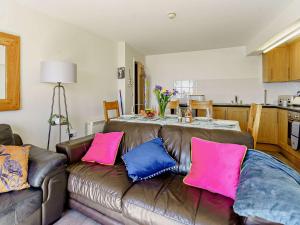 uma sala de estar com um sofá castanho com almofadas cor-de-rosa e azul em 3 bed in Pendine 82383 em Pendine