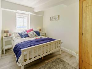 Un dormitorio con una cama con sábanas moradas y una ventana en 3 bed in Pendine 82383, en Pendine