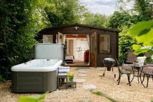 - un petit hangar avec une baignoire et un grill dans l'établissement Copperbeech - Luxury Holiday with Private Hottub, à Blandford Forum