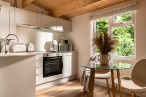 a kitchen with a glass table and a fireplace at Copperbeech - Luxury Holiday with Private Hottub in Blandford Forum +16 photos