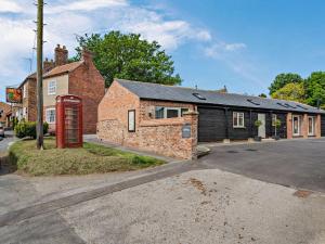 a brick building with a red phone booth in front of it at 2 bed property in Driffield 88238 in Lund