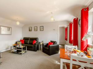 a living room with black furniture and red accents at 1 bed in Cinderford 88271 in Cinderford
