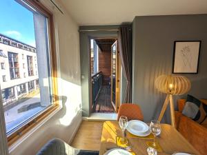 a dining room with a table and a large window at Stunning Modern Coventry City Centre Apartment in Coventry