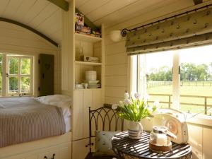 1 bed property in Benenden BT096 في Benenden: غرفة نوم بسرير وطاولة عليها ورد