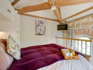1 bed property in Bedale G0044 في Hornby: غرفة نوم بسرير وبطانية ارجوانية