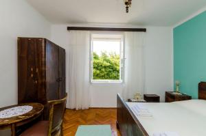 a bedroom with a bed and a table and a window at Apartment Pavo in Dubrovnik