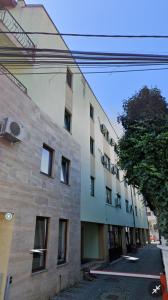 a building on a street with a tree next to it at Daylight Apartments Sibiu in Sibiu