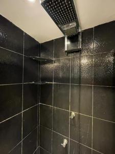a black tiled bathroom with a shower with at Casa Com Piscina Porto Maravilha in Rio de Janeiro