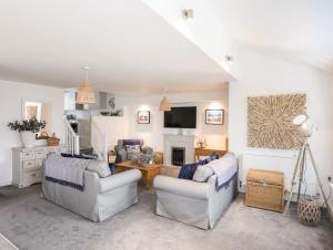 a living room with two couches and a tv at Ty Glan y Mor - Pwllheli in Pwllheli