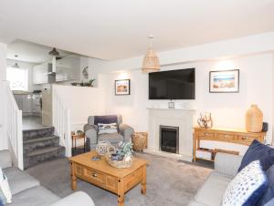 a living room with a fireplace and a tv at Ty Glan y Mor - Pwllheli in Pwllheli