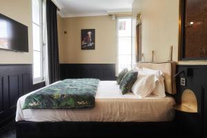 - une chambre avec un lit dans une pièce dotée d'une fenêtre dans l'établissement Maison Bayard, à Montpellier