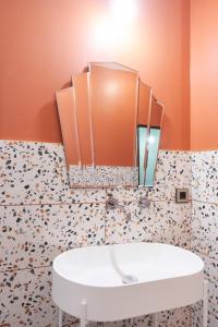 La salle de bains est pourvue d'un lavabo blanc et de murs orange. dans l'établissement Maison Bayard, à Montpellier