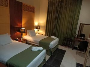 En eller flere senger på et rom på Doha Dynasty Hotel