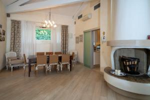 a dining room and living room with a table and a fireplace at VILLA INFINITY - Regarda Travel in Bardolino +38 photos