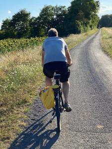 a man riding a bike down a road at Domaine la Boulinière - La Biche in Journet