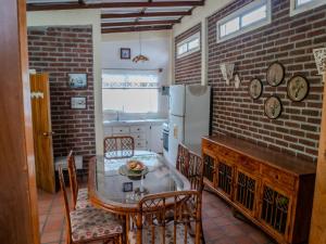 kuchnia ze stołem i krzesłami oraz ceglaną ścianą w obiekcie Las villas de Yoly w mieście Playas