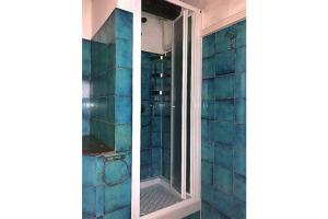 La salle de bains est pourvue d'une douche avec du carrelage bleu. dans l'établissement Bellavista, à Campese