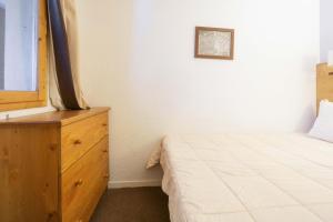 a bedroom with a bed and a dresser and a window at Appartement Belle Plagne in La Plagne Tarentaise