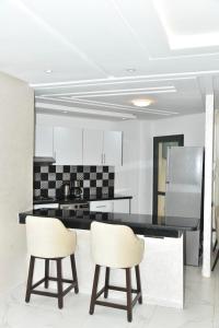 BRAND NEW! 3 Bedroom Apartment in the Heart of Kenitra في القنيطرة: مطبخ مع كرسيين بيض وكاونتر