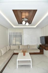 BRAND NEW! 3 Bedroom Apartment in the Heart of Kenitra في القنيطرة: غرفة معيشة مع أريكة وطاولة