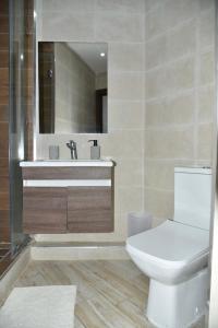 een badkamer met een toilet, een wastafel en een spiegel bij BRAND NEW! 3 Bedroom Apartment in the Heart of Kenitra in Kenitra