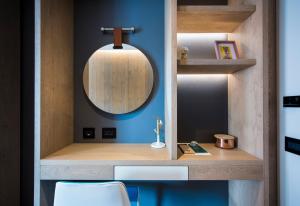 baño con espejo y pared azul en Hotel Principe delle Nevi, en Breuil-Cervinia