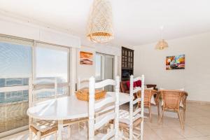 a dining room with a white table and chairs at Sea Side Apartment by SIDE VILLAS in Armação de Pêra