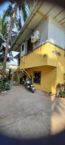 een geel gebouw met een motor buiten geparkeerd bij Ashirvad cottage in Alībāg