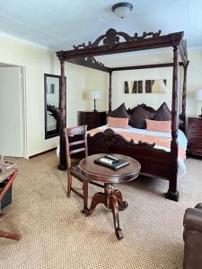 a bedroom with a large bed with a table and a chair at Limpopo Guest Manor in Polokwane