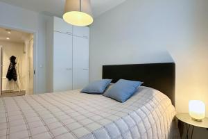 a bedroom with a bed with two blue pillows at Pramea Apartments Haapaniemenkatu in Kuopio
