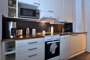 een keuken met een fornuis en een magnetron bij City Apartment Haapaniemenkatu in Kuopio