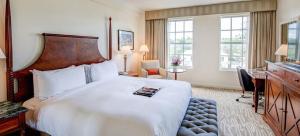 una camera d'albergo con un grande letto e una scrivania di Hamilton Princess & Beach Club A Fairmont Managed Hotel a Hamilton